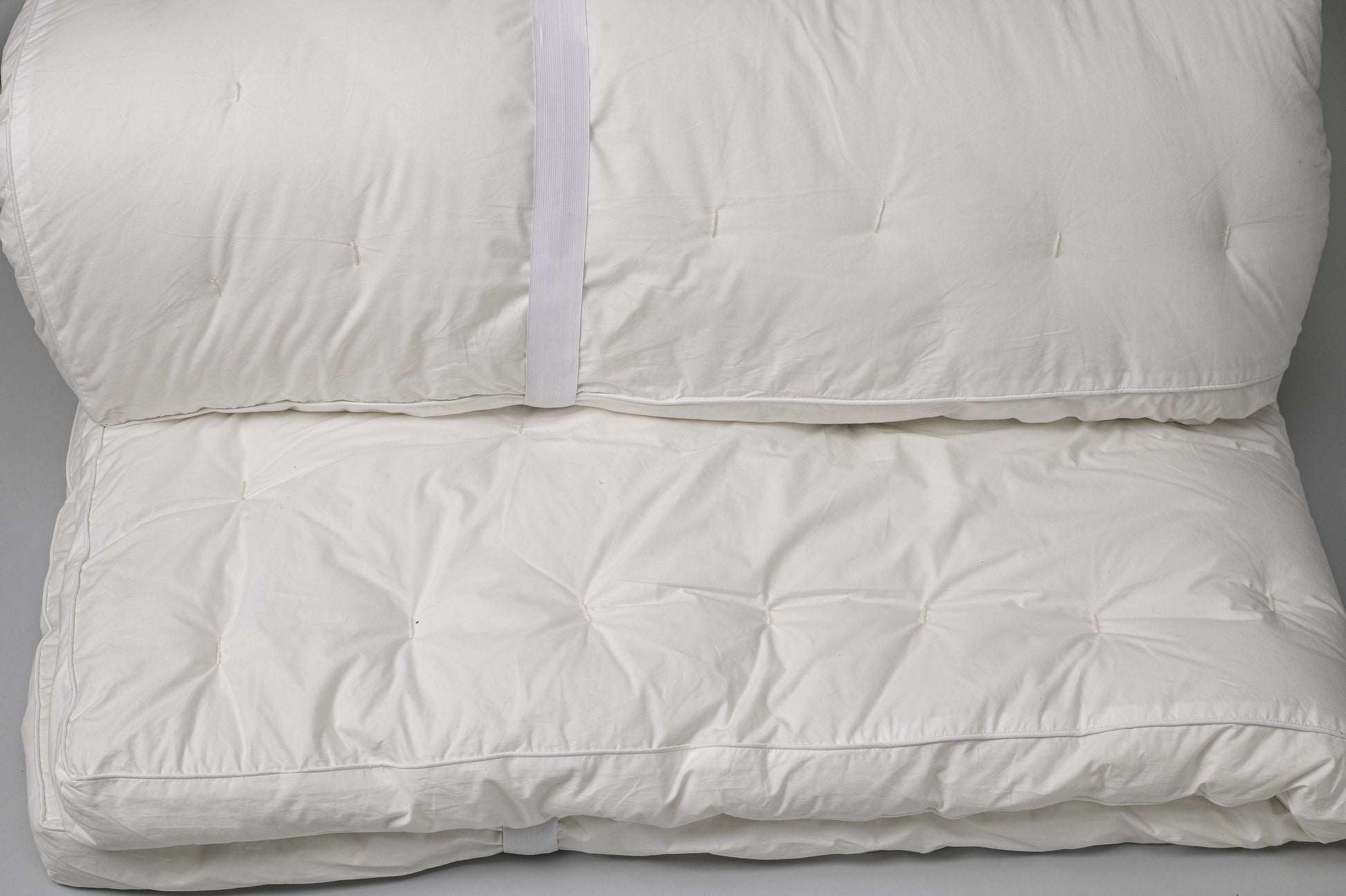 A close up of the cotton covering for the Sleep&eyond myWooly Latex Topper while rolled up.