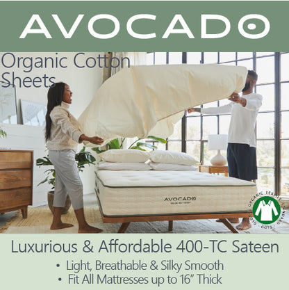 Picture of a couple putting Avocado Organic Cotton Sheets onto their mattress. The sheets are luxurious and affordable 400-TC sateen. Light, breathable and silky smooth. Fit all mattresses up to 16" thick.