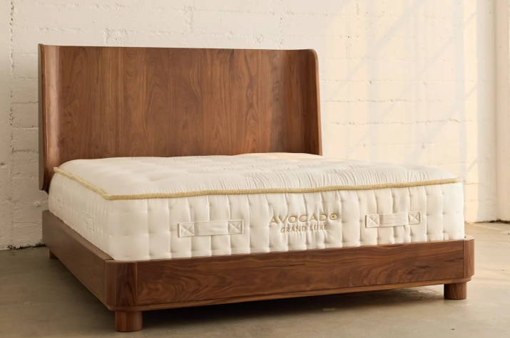 A picture showing the natural and organic Avocado Grand Lux resting on top of the finely wood crafted Montecito Bedframe in a Walnut finish. 
